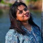 Crafting Captivating Headlines: Your awesome post title goes here Outdoor portrait of a woman in a blue kurti by a lakeside with a gentle smile.